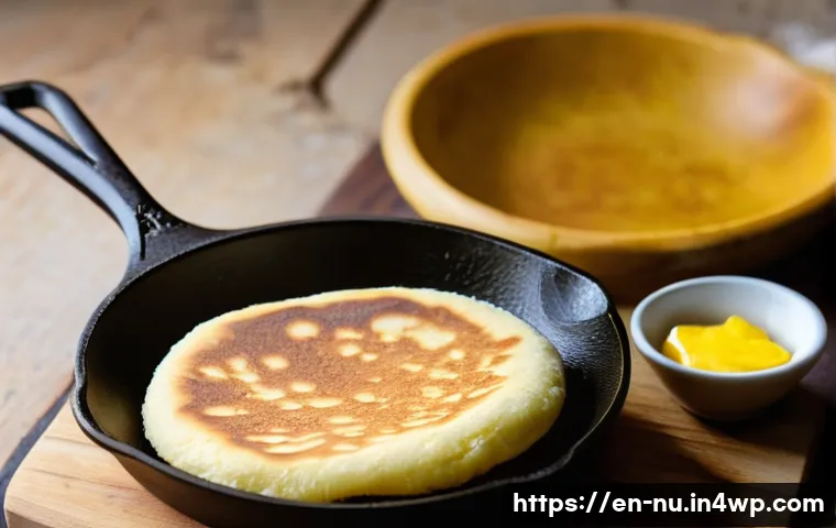 콜롬비아식 아레파 만드는 법 - A rustic kitchen scene showcasing a close-up of a cast-iron skillet on a stovetop with golden-brown ...